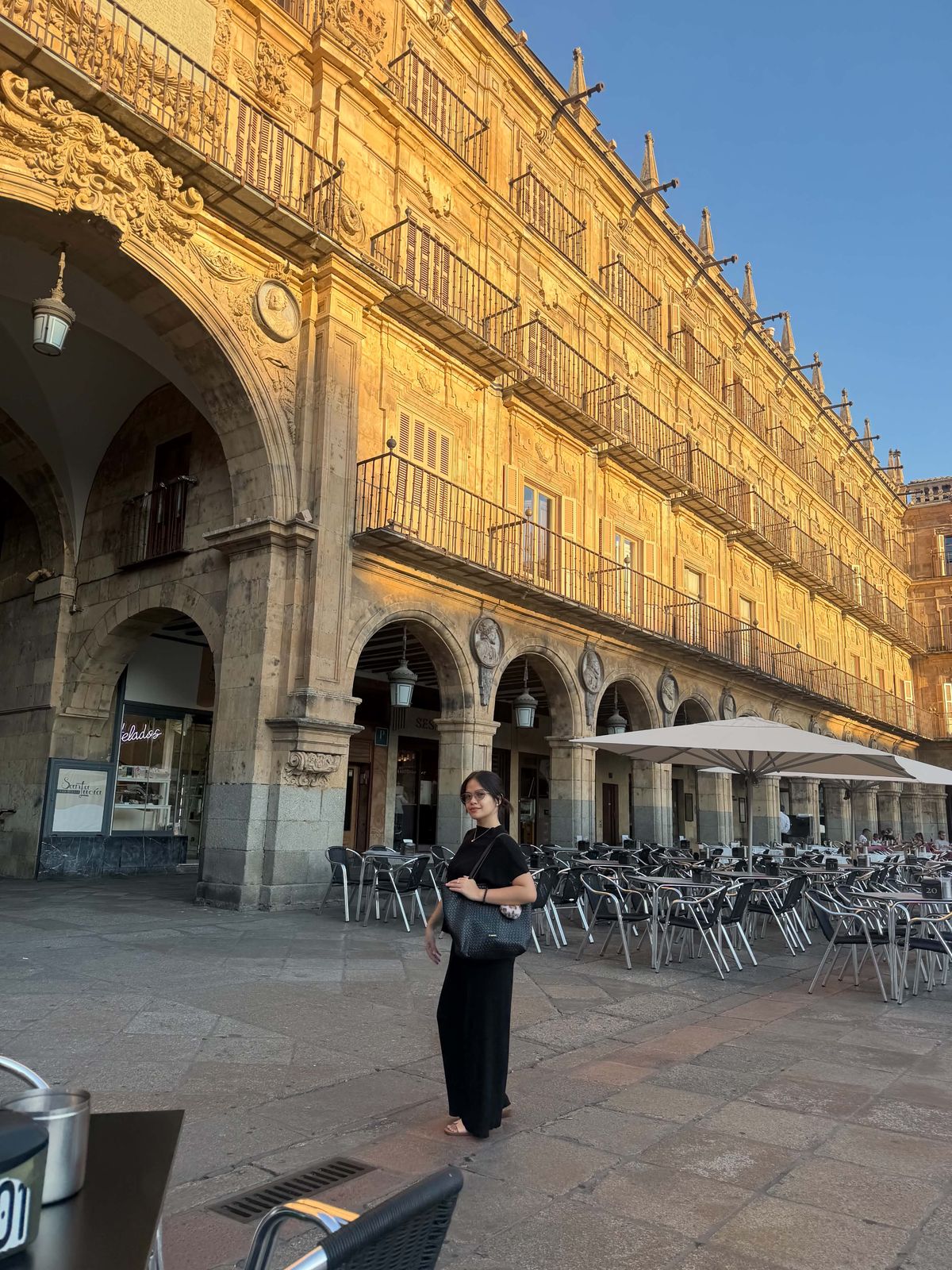 Sherann standing in Salamanca's Plaza Mayor at golden hour
